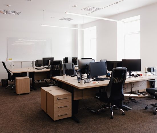 IT open space office. Computer Work Stations. Office Workplace with windows.